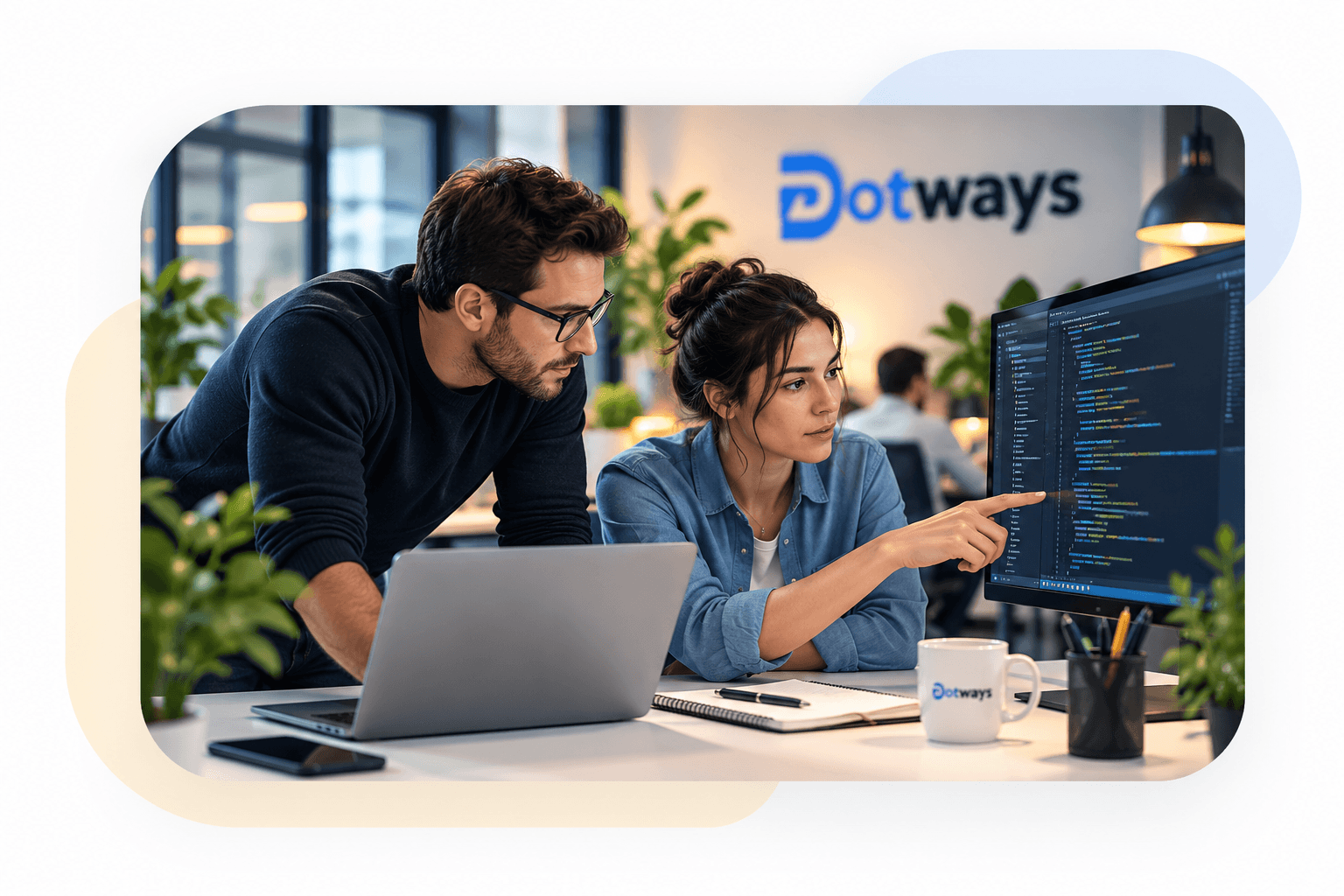 Deux ingénieurs Dotways collaborent devant un écran de code dans un bureau lumineux